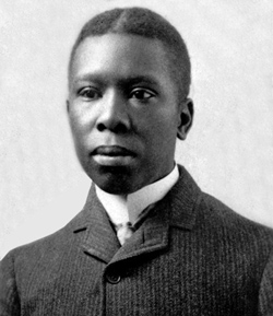 A black and white portrait of poet Paul Laurence Dunbar. He is wearing a formal suit and looking directly at the camera with a serious, intense expression.