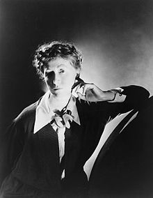 Marianne Moore posing for the camera for photography George Platt Lynes. Moore is wearing a black dress.